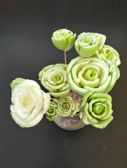 The creation of roses from the base of the bok choy vegetable stem, arranged into a beautiful arrangement of roses, and several flowers that are lying down, arranged into a beautiful flower.