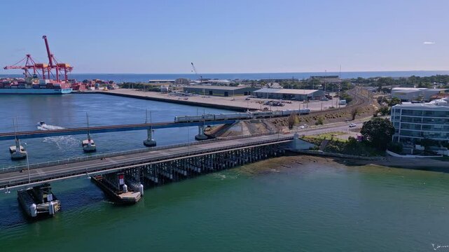 Train crosses Fremantle Railway Bridge with container port in background, Perth, Western Australia
