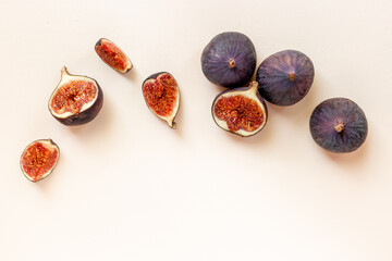Whole and cut fresh ripe figs on stone table. Top view