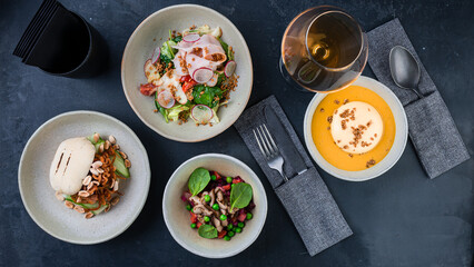 Set pumpkin cream soup, salad with chicken ham, radish, spinach, lettuce and cherry tomatoes, vinaigrette salad with boiled vegetables and vegan burger.