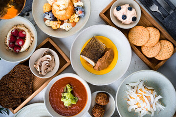 Set of fried fish, pate, breaded mozzarella cheese ball, cottage cheese casserole, red tomato soup, cream with raspberries and shortbread crumbs and crackers.