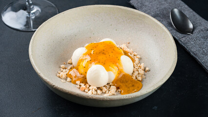 Dessert sweet cream with passion fruit jam and shortbread crumbs.