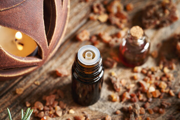 A dropper bottle of essential oil with myrrh resin on a table