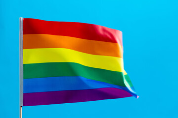 Rainbow flag waving on blue background