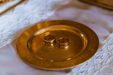Elegant Golden Wedding Rings on Intricately Designed Brass Plate with Lace Detailing