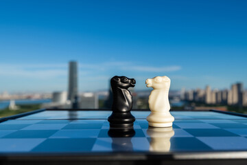 Two chess knights on city background © xy