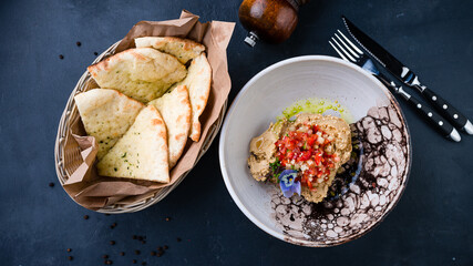 Chickpea hummus with tomatoes, cucumber, microgreens and flatbread.