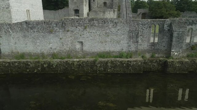 Historic Adare Castle ruins by the river Maigue in County Limerick, Ireland on a cloudy day