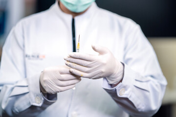 surgery doctor holding up medical syringe. surgeon staff preparing therapy operation lifting needle that got medicine from vial. cosmetologist ready holding medicine syringe kit for plastic surgery