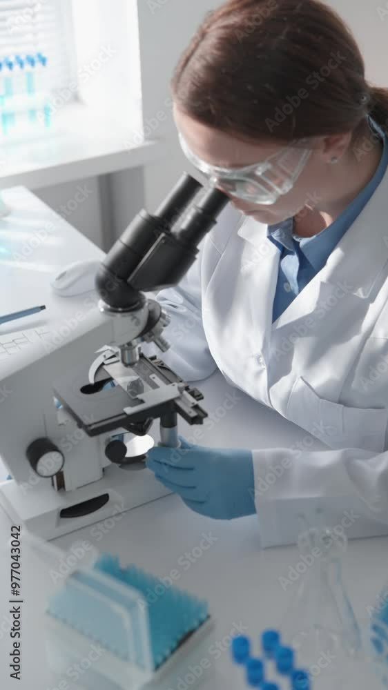 Poster In a laboratory, a scientist uses a microscope to study scientific concepts and analyze samples for research. The diverse keywords reflect areas like biology, chemistry, and innovation