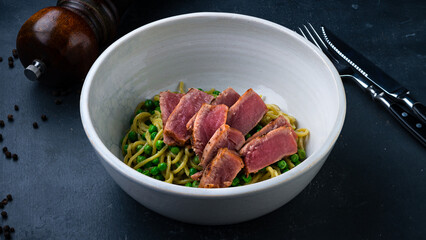 Italian lunch pasta with seared tuna and green peas.