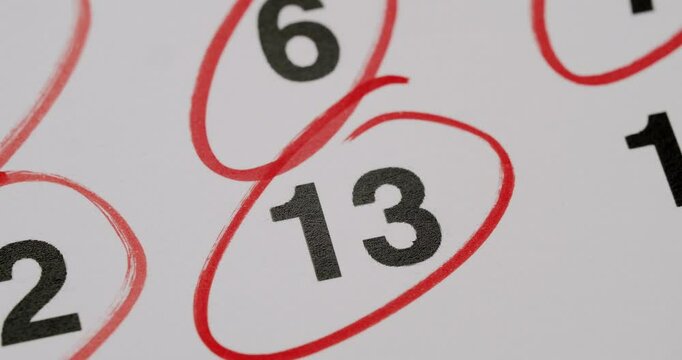 Close-up of the number 13 circled in red on a calendar, highlighting a significant date or event. Number 13 Circled In Red On A Calendar Page For Important Event Reminder