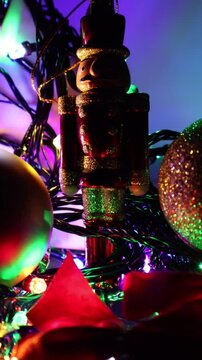 Una toma de cerca de un soldadito de juguete rodeado de bolas de navidad y luces de colores. Decoraci&oacute;n de navidad y fin de a&ntilde;o