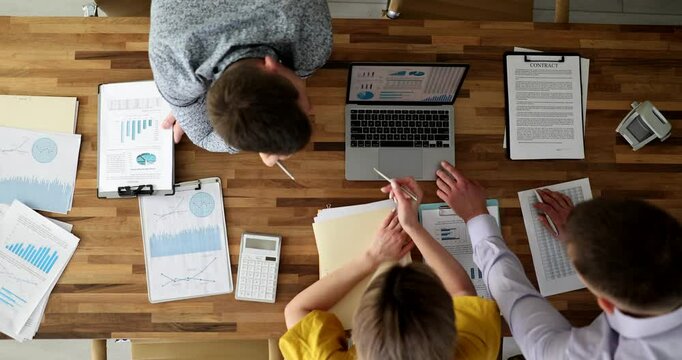 Collaboration and discussion of financial and commercial indicators documents and laptop top view. Business team communicating commercial indicators