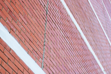 A detailed close up of a red brick wall covered in fresh snow on it
