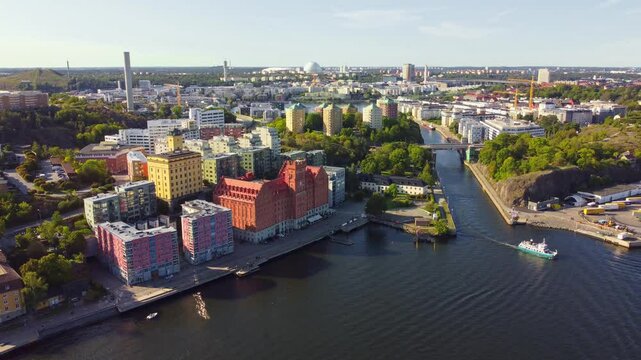 Stockholm, Sweden. The old industrial area of Saltsj&ouml;qvarn, Danvikstull and bridge, Globen and Hammarby sj&ouml;stad, boats passing by, clear sky, late summer.