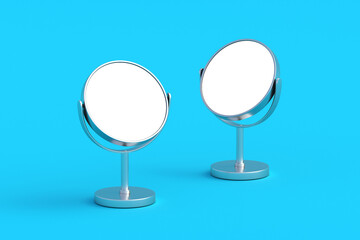 Two desktop makeup mirrors with white isolated space on blue background. Cosmetic accessories. 3d render