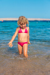 A child bathes and splashes in the sea. Selective focus.