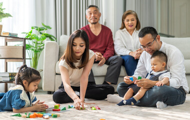 Happy asian family spending quality time together at home, parents playing with kids on the floor, grandparents watching and smiling family bonding, love, care, parenting, indoor lifestyle moments