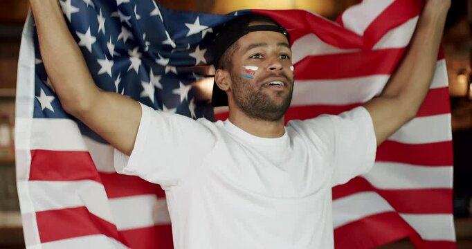 Soccer fan celebrating victory of team in sports bar, Loyal football fan supporting their team. USA Supporter. Happy mixed race supporter cheering and exulting after winning.