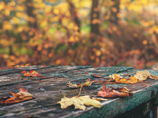 Close-up of a weathered wooden table surface with autumn leaves.