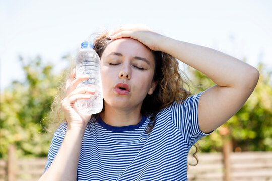 Young woman having hot flash and sweating in a warm summer day