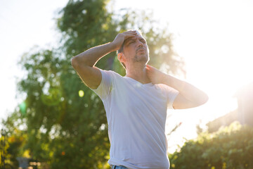 Young man having hot flash and sweating in a warm summer day