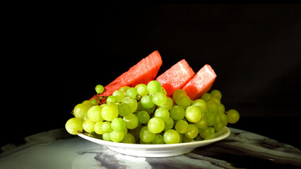 Watermelon Slices and Ripe Green Grapes on a Plate