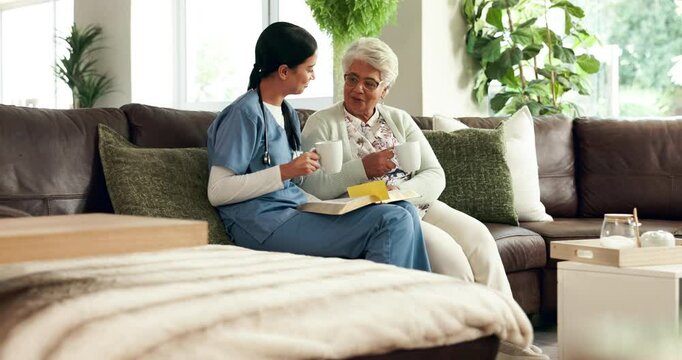 Couch, senior woman and caregiver with book for reading, listening and discussion with tea cup at home. Sofa, elderly person and female nurse for bible session, guidance and wisdom in retirement
