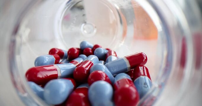 Scattered medical pills from jar on table. Medicines and health treatment concept