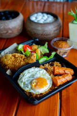 American fried rice with sausages, fried egg, fried chicken, cucumber and tomatoes,Thai style