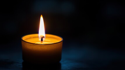 A single lit candle emits a warm flame, casting gentle light in a dark setting, creating a serene and calming atmosphere