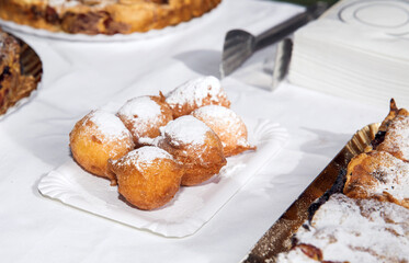 Delicious powdered sugar doughnut balls on paper plate, crispy golden brown dessert, tempting fried delicacy, sweet treat concept