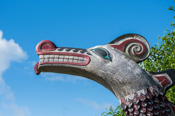 Unique traditional Native American totem pole head carved in the shape of a dragon in Ketchikan, Alaska, USA