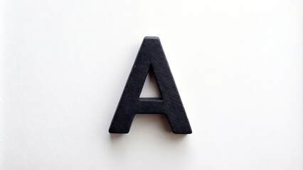 A small black lowercase letter 'a' cutout from paper on a white background is a design element that