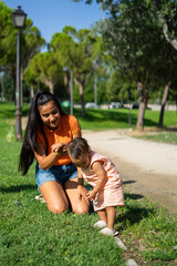 Young Latin mother with her 1 year old baby daughter enjoying a sunny day outdoors