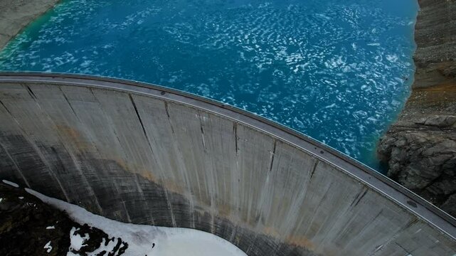 4k Drone Aerial Panning Tilt Shot Of Lac de Moiry Dam With Road On Top And Light Blue Glacial Water In Grimentz Switzerland