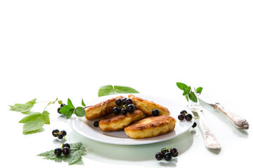 Fried curd cheese pancakes with black currants, isolated on white background