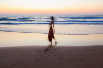 Summer mood. girl on the beach. happy young girl in a dress sitting on the beach.  soft focus and...