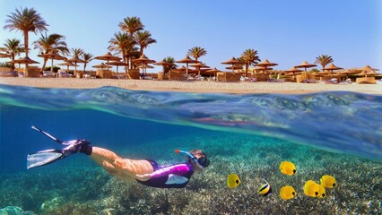 Woman snorkeling near tropical coral reef. Beach with palms and sun umbrelas on the background, Red...