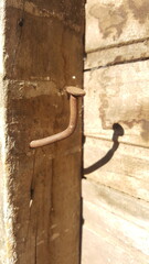 Prego torto afixado na viga de madeira.