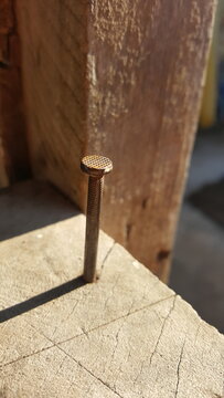 Viga de madeira com prego velho enferrujado.