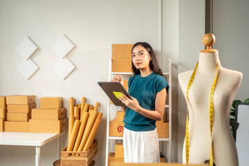 Fashion designer is managing her online store orders using a digital tablet