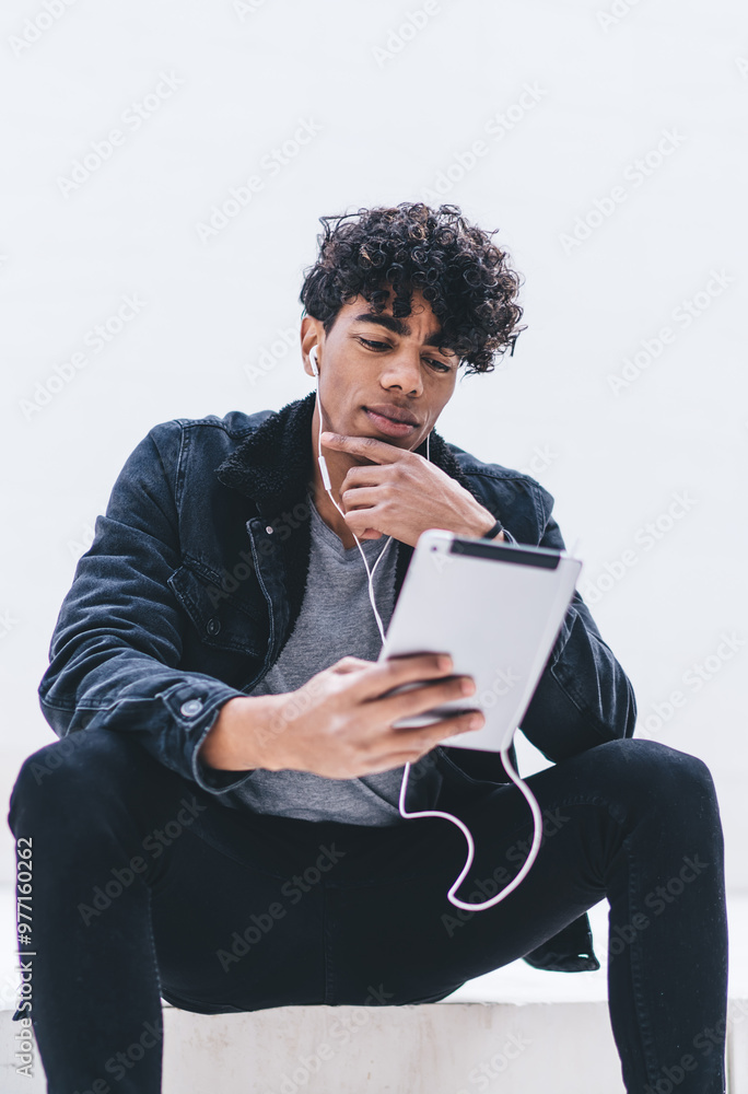 Poster man with digital tablet making virtual communication at social website while listening music audio s