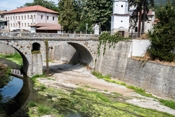 Old stone bridge over a dried up river in a town of Bulgaria as drought concept