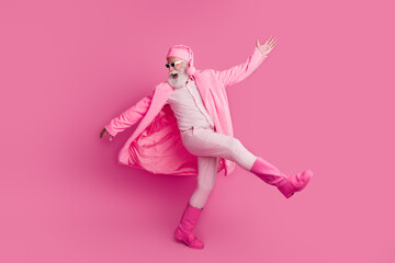 Photo of cool funny optimistic senior man wear trendy bathrobe boots dance party empty space isolated on pink color background