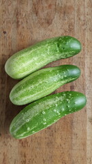 grupo de pepinos verdes em mesa rústica de madeira.