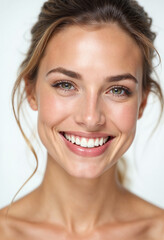 Close-up portrait of a smiling woman with clean teeth and fresh hair, set against a white background.






