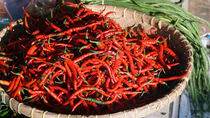 Pile of ripe red chilies in a bamboo basket. Focus selected