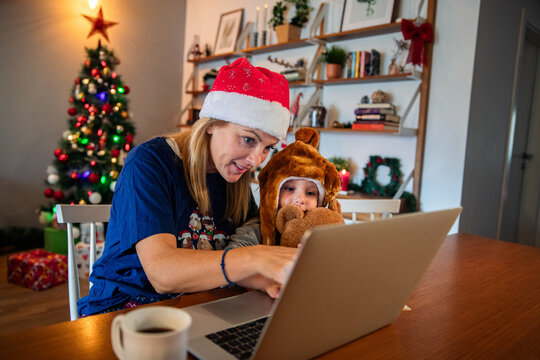 Mom and kid doing Christmas online shopping with laptop and credit card